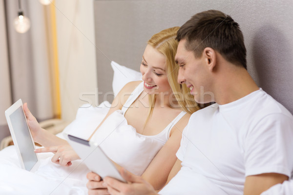 smiling couple in bed with tablet pc computers Stock photo © dolgachov