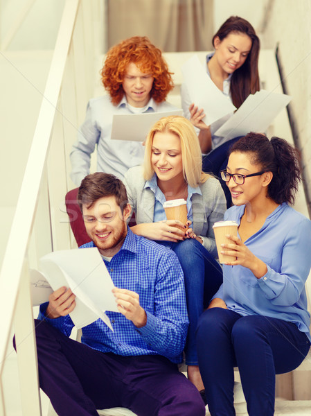 Stock photo: team with papers and take away coffee on staircase
