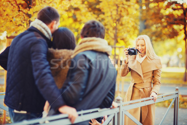 group of friends with photo camera in autumn park Stock photo © dolgachov