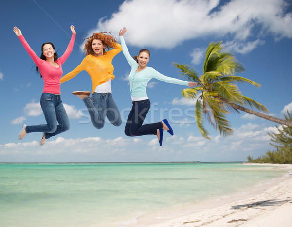 group of smiling young women jumping in air Stock photo © dolgachov