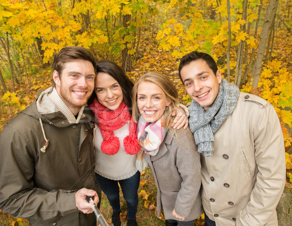 Stock photo: smiling friends taking selfie in autumn park