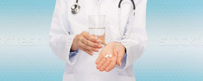 close up of doctor offering pills and water Stock photo © dolgachov
