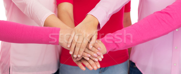 close up of women in pink shirts with hands on top Stock photo © dolgachov