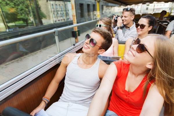 group of smiling friends traveling by tour bus Stock photo © dolgachov