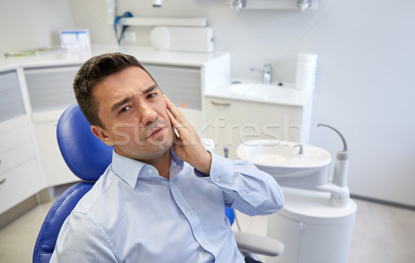 Człowiek ból zęba posiedzenia stomatologicznych krzesło ludzi Zdjęcia stock © dolgachov