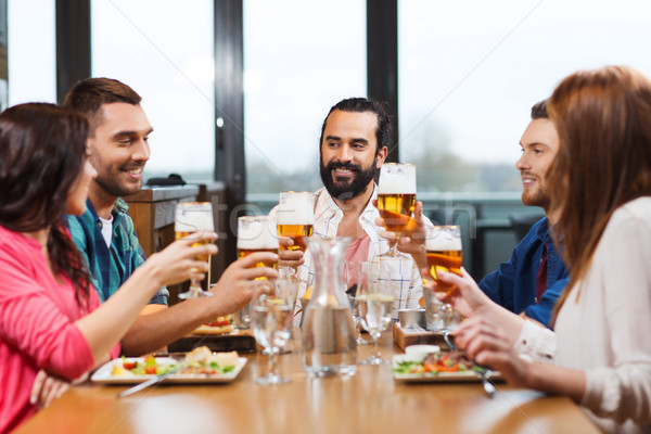 friends dining and drinking beer at restaurant Stock photo © dolgachov