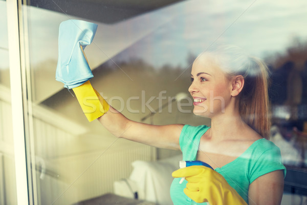 happy woman in gloves cleaning window with rag Stock photo © dolgachov