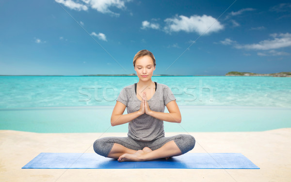 woman meditating in lotus yoga pose on beach  Stock photo © dolgachov