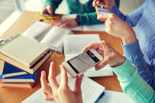 students with smartphones making cheat sheets Stock photo © dolgachov