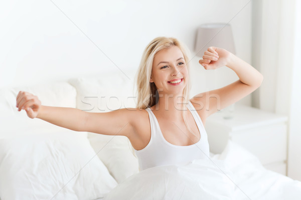 young woman stretching in bed after waking up Stock photo © dolgachov