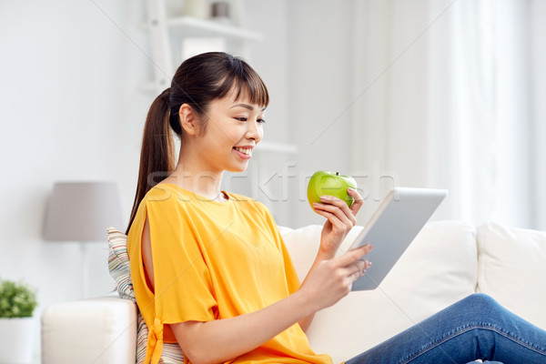 happy asian woman with tablet pc and apple at home Stock photo © dolgachov