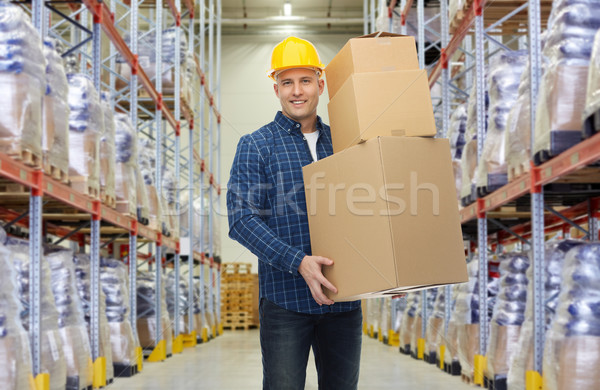 happy man or loader with box at warehouse Stock photo © dolgachov