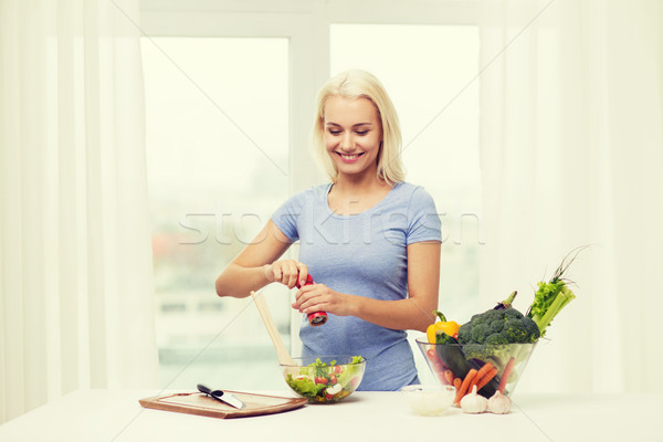 smiling woman cooking vegetable salad at home Stock photo © dolgachov