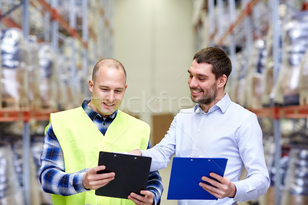 worker and businessmen with clipboard at warehouse Stock photo © dolgachov