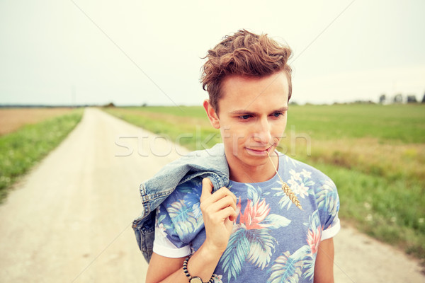 sad young hippie man walking along country road Stock photo © dolgachov