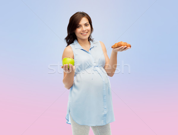 Stock photo: happy pregnant woman with apple and croissant