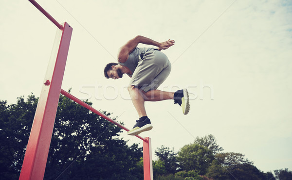 молодым человеком прыжки горизонтальный Бар улице фитнес Сток-фото © dolgachov