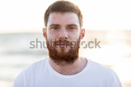 face of happy smiling young man on beach Stock photo © dolgachov