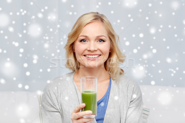 happy woman drinking green juice or shake at home Stock photo © dolgachov