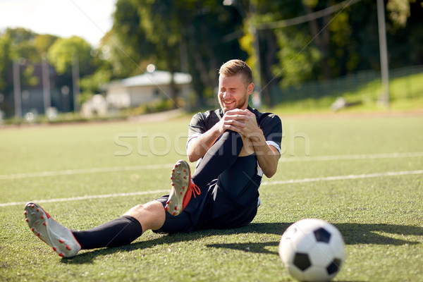 injured soccer player with ball on football field Stock photo © dolgachov