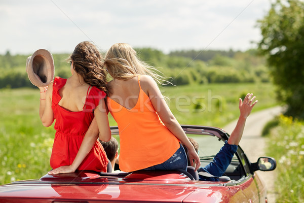 happy friends driving in cabriolet car at country Stock photo © dolgachov