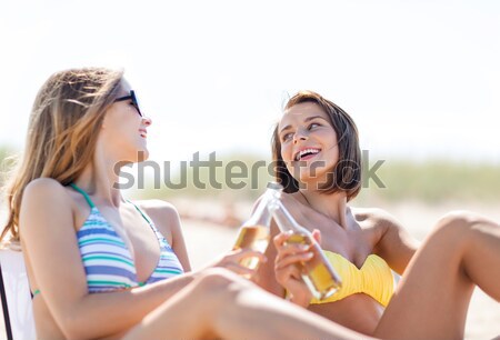 happy young women with drinks sunbathing on beach Stock photo © dolgachov