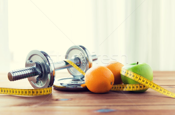 close up of dumbbell, fruits and measuring tape Stock photo © dolgachov