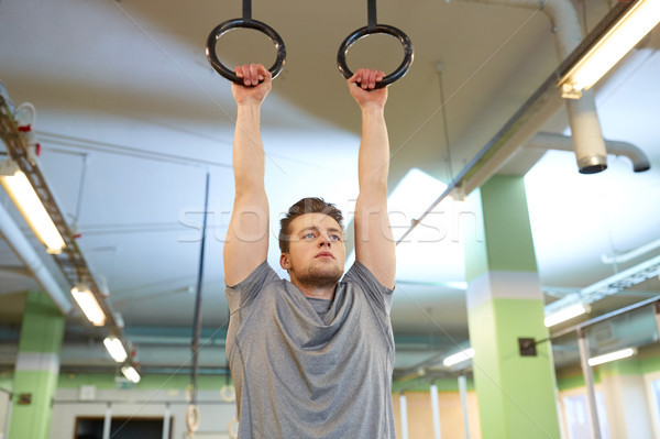 man exercising and doing ring pull-ups in gym Stock photo © dolgachov
