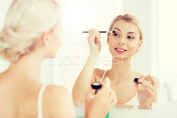 woman with makeup brush and eyeshade at bathroom Stock photo © dolgachov