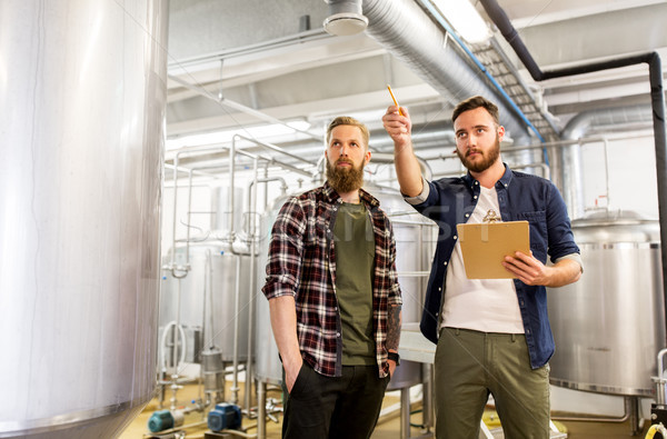 men with clipboard at craft brewery or beer plant Stock photo © dolgachov