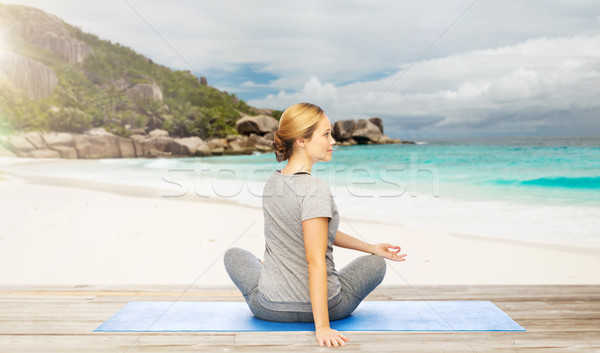 Stock photo: woman doing yoga in twist pose on beach