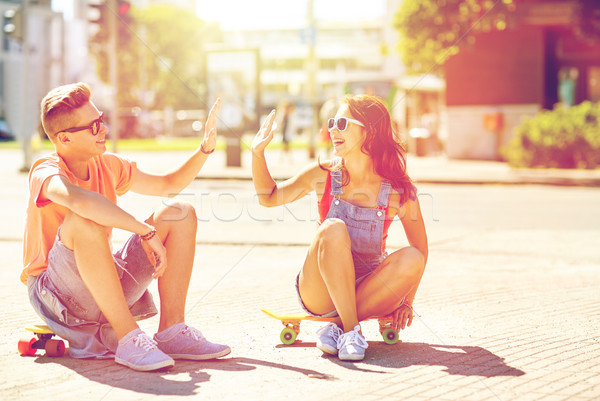 teenage couple with skateboards on city street Stock photo © dolgachov