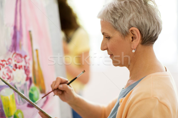 senior woman artist painting at art school Stock photo © dolgachov