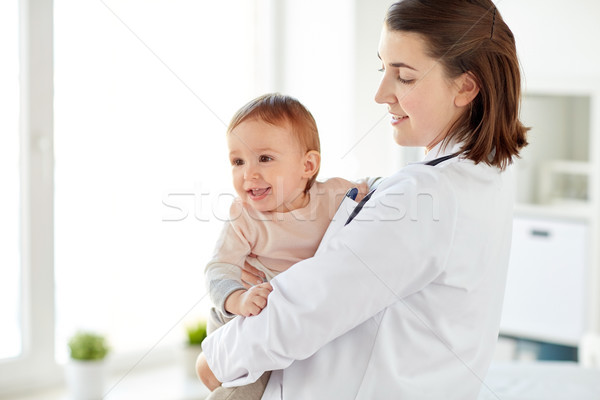 doctor or pediatrician holding baby at clinic Stock photo © dolgachov