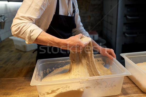 baker making bread dough at bakery kitchen Stock photo © dolgachov