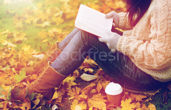 woman with book drinking coffee in autumn park Stock photo © dolgachov