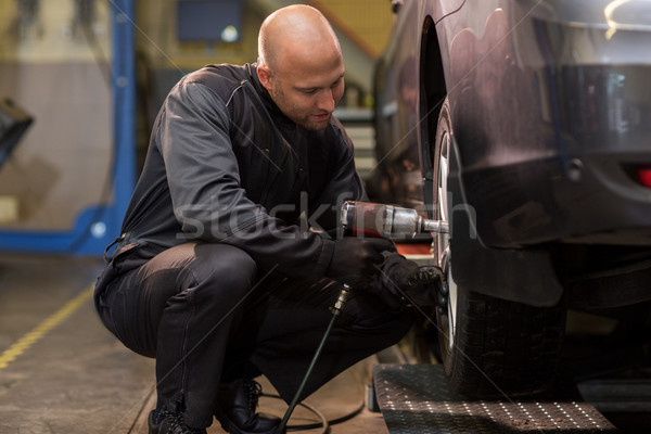 auto mechanic with screwdriver changing car tire Stock photo © dolgachov