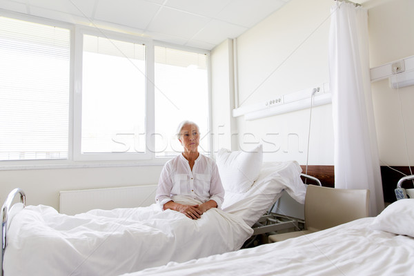 sad senior woman sitting on bed at hospital ward Stock photo © dolgachov