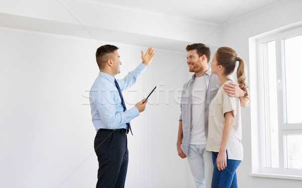 Stock photo: couple and realtor with tablet pc at new home