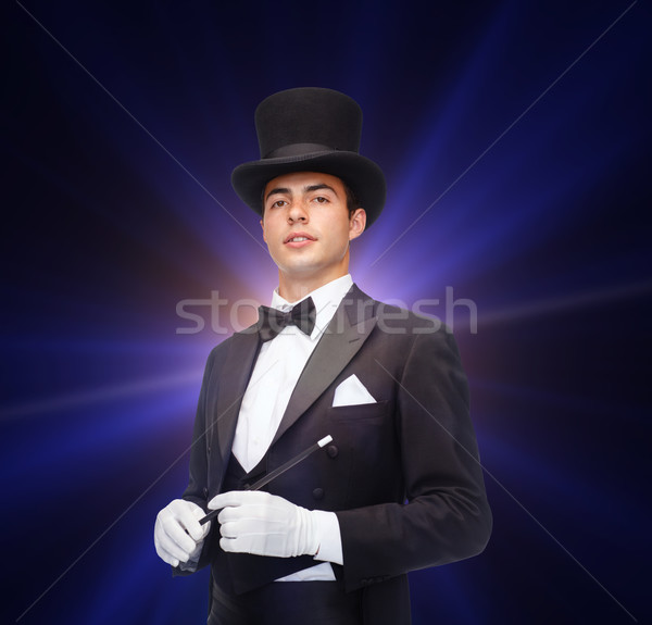 magician in top hat with magic wand showing trick Stock photo © dolgachov