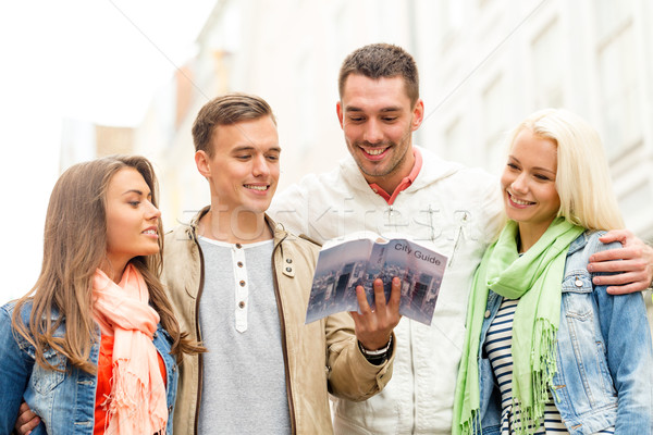 group of friends with city guide exploring town Stock photo © dolgachov