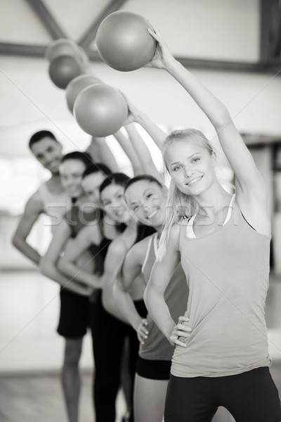 group of smiling people working out with ball Stock photo © dolgachov