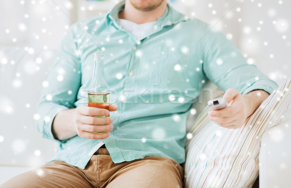 man with beer and remote control at home Stock photo © dolgachov