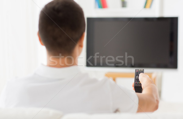 man watching tv and changing channels at home Stock photo © dolgachov