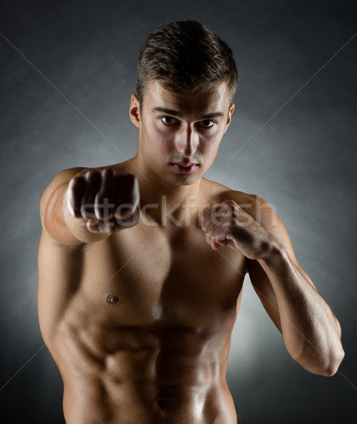 young man on fighting stand over black background Stock photo © dolgachov