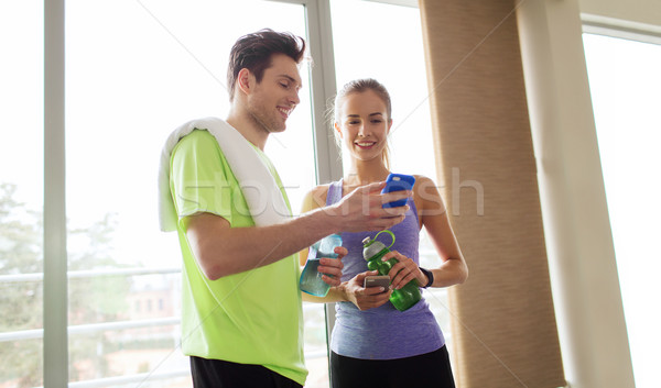 Szczęśliwy kobieta trener smartphone siłowni Zdjęcia stock © dolgachov