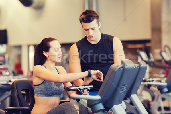 woman with trainer on exercise bike in gym Stock photo © dolgachov