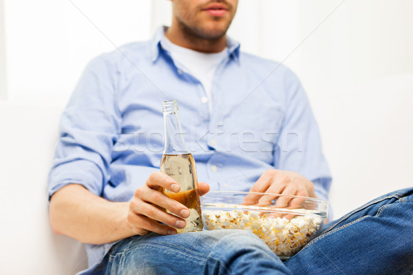 close up of man with popcorn and beer at home Stock photo © dolgachov