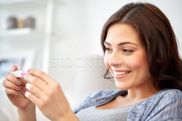 Heureux femme regarder maison test de grossesse grossesse Photo stock © dolgachov