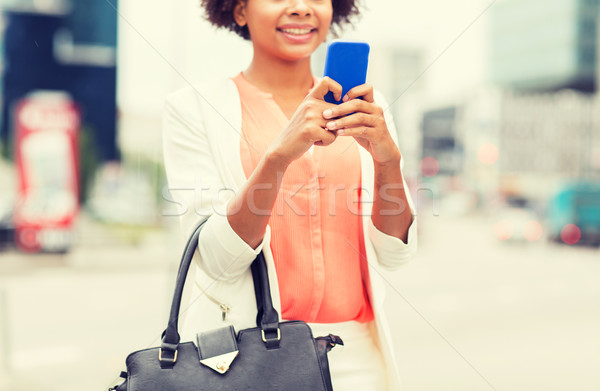 close up of african woman with smartphone in city Stock photo © dolgachov